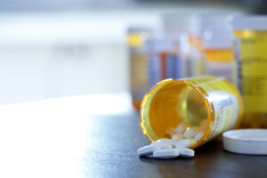 Open Prescription Medication Bottle On Countertop