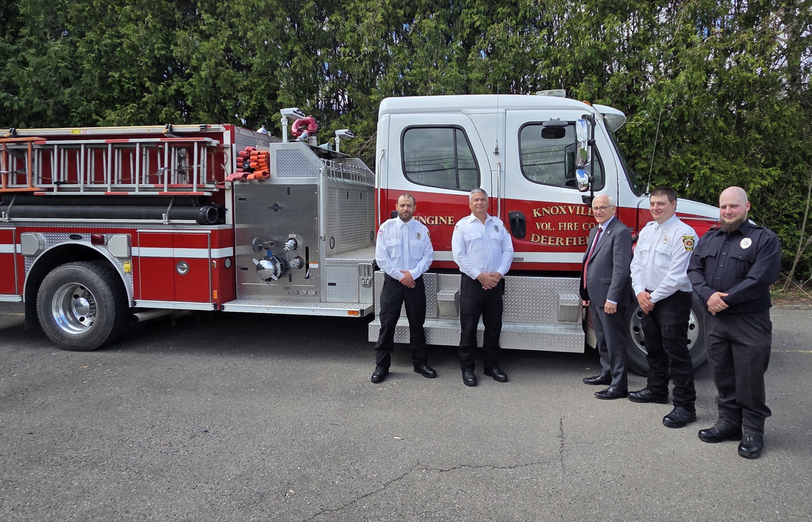 Sen. Yaw standing with 4 figherfighters from Knoxville Volunteer Fire Company in front of one of their fire trucks.