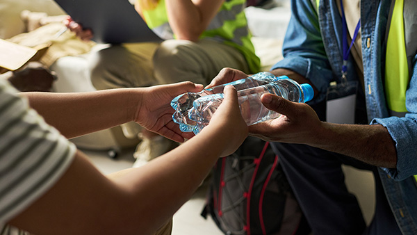 two people exchanging bottles of water